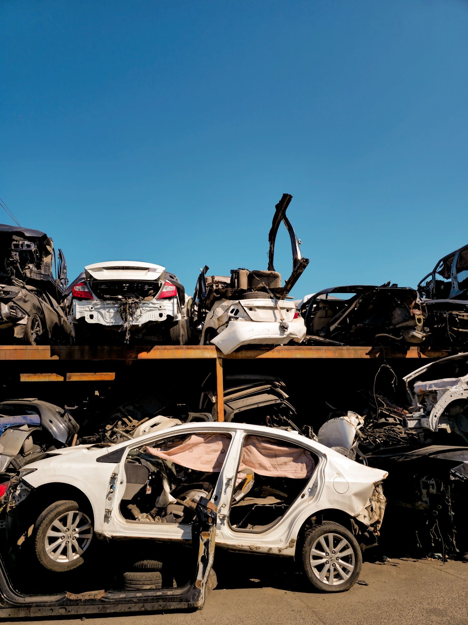 End-of-life vehicles stacked in an auto salvage yard for recycling